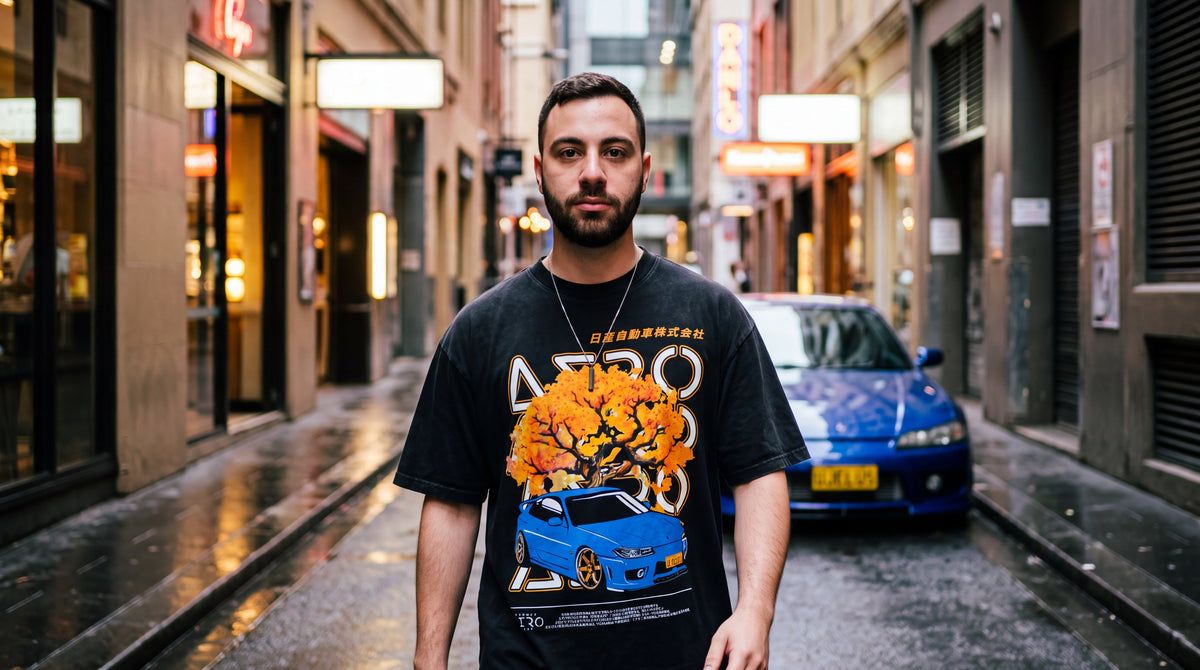 The UJELUS Tee in a wet Sydney laneway, with a blue S15 Silvia behind him